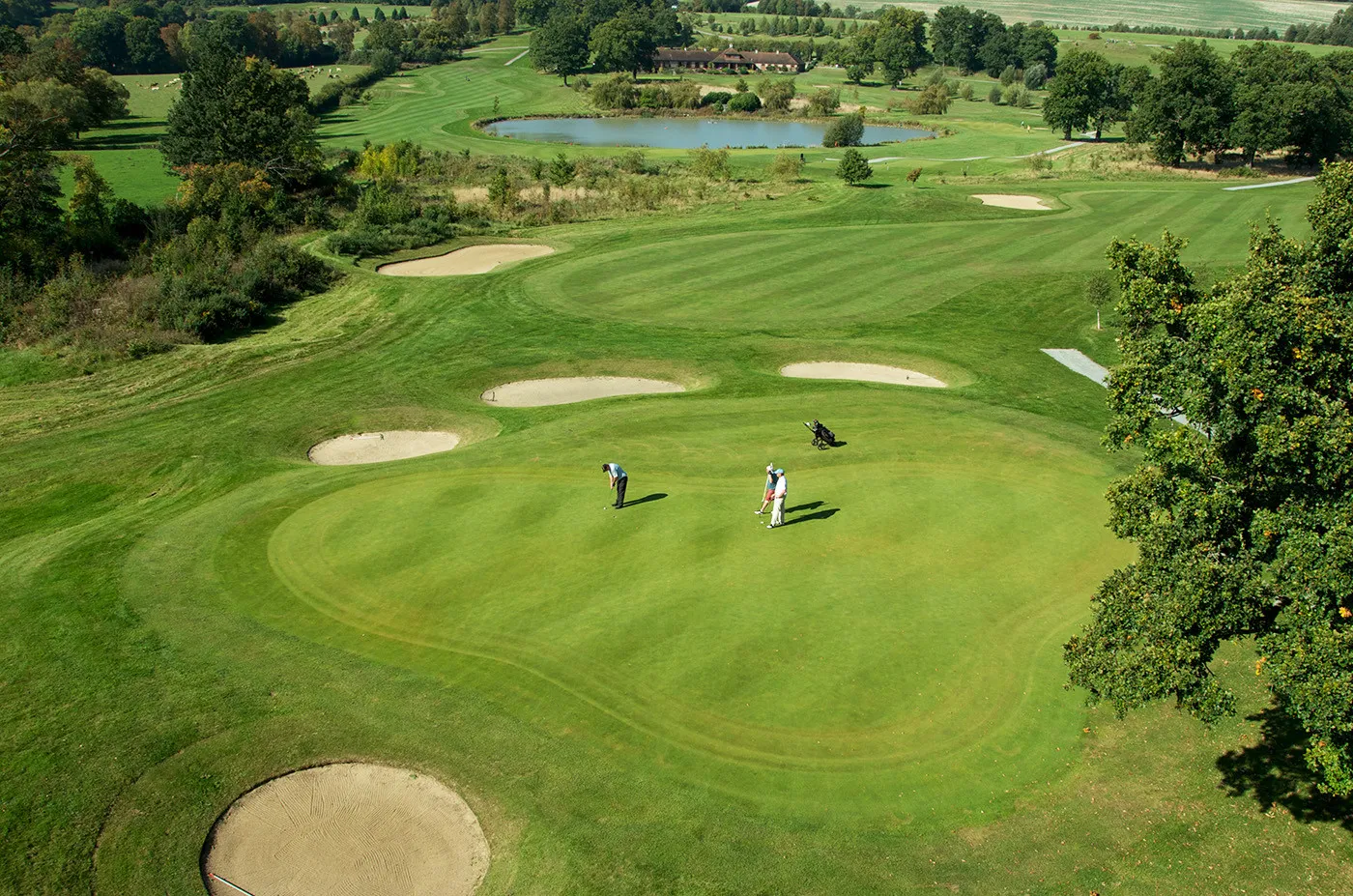 Three Male Golfers On A Putting Green From A Drone